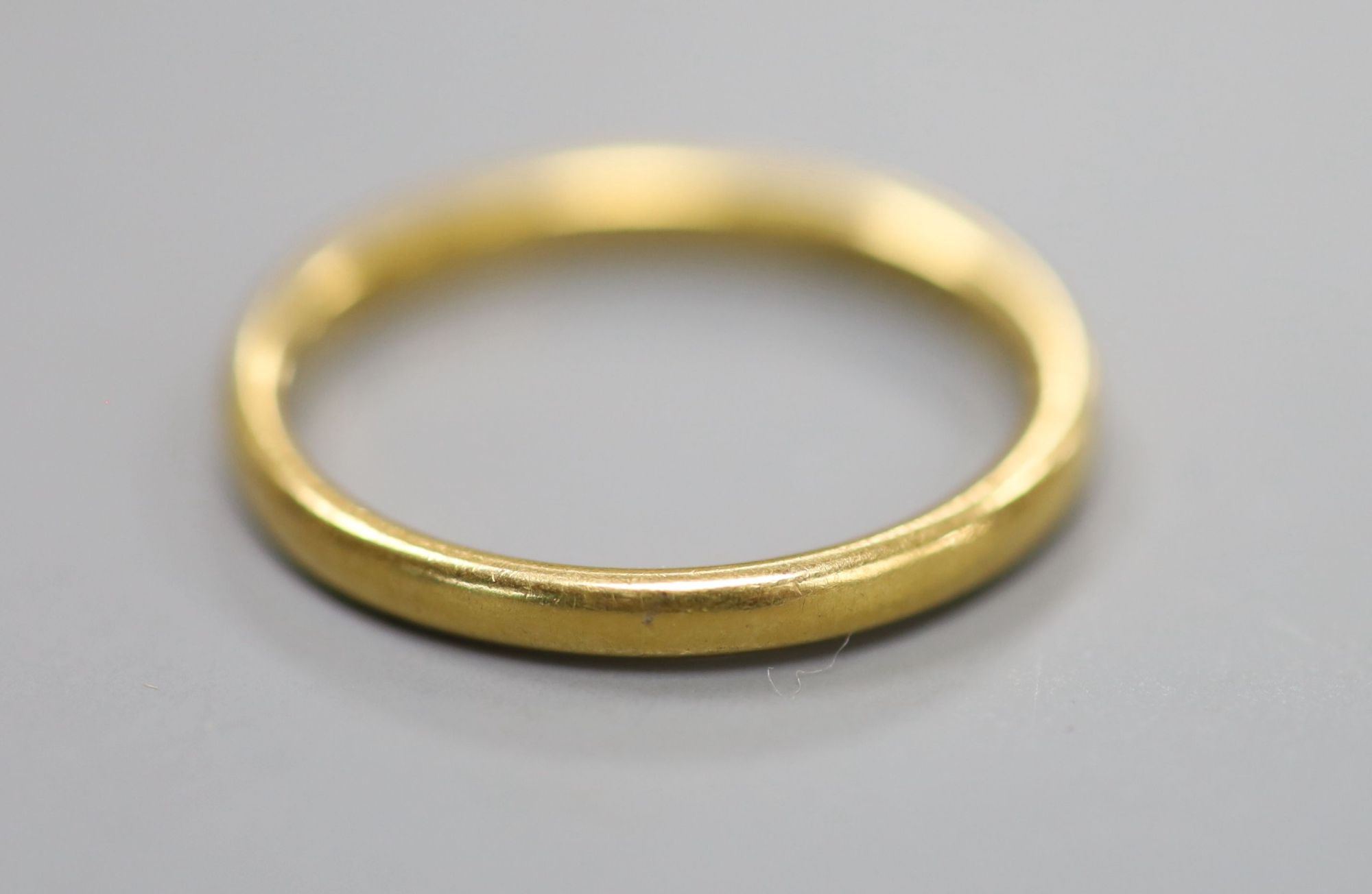 An Edwardian 22ct gold wedding band, with engraved inscription, size O, 3.6 grams.